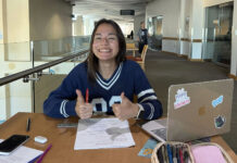 Students at SLCC confront procrastination as deadlines pile up Stephanie smiling and giving two thumbs up while studying