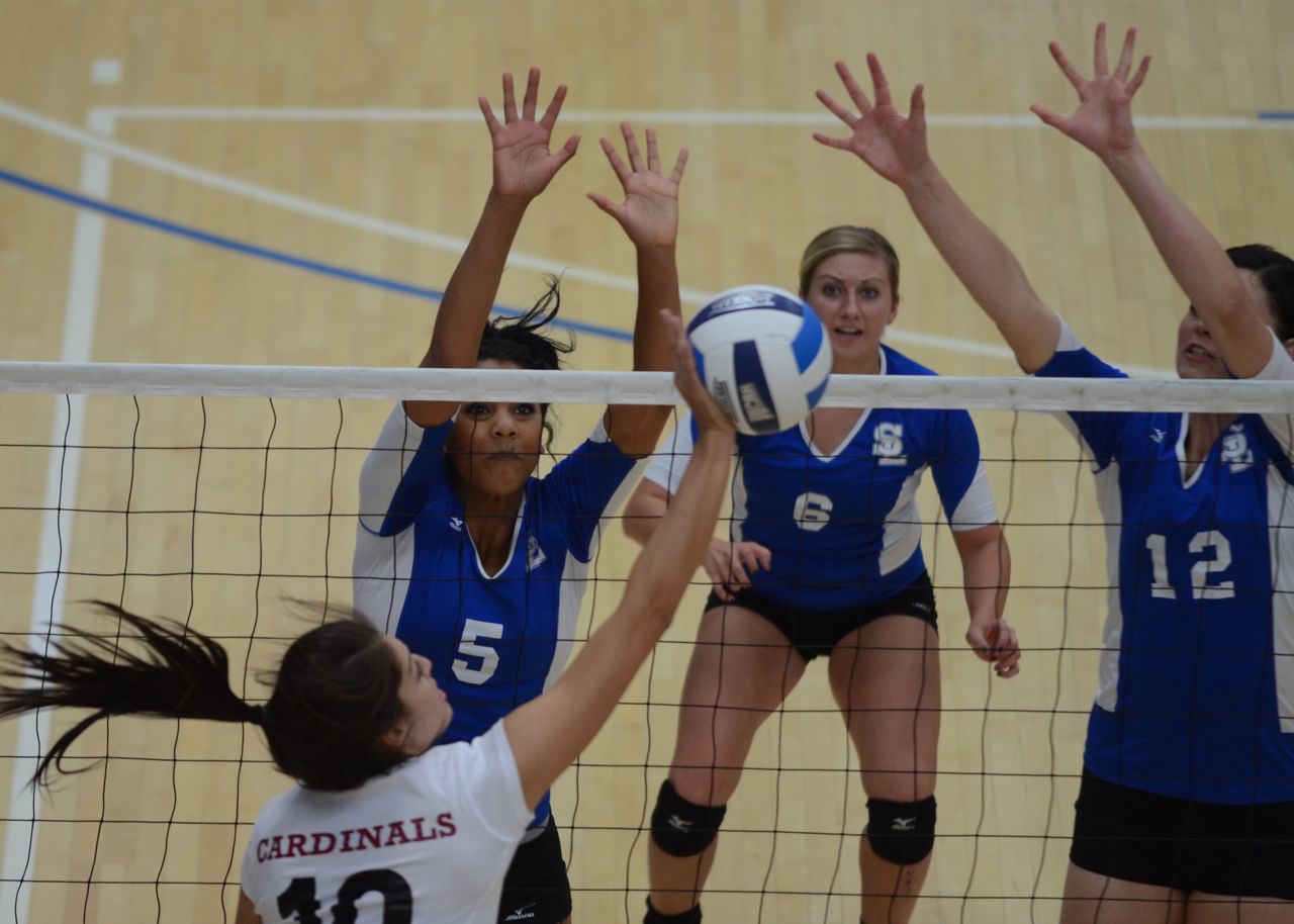 The Bruins dominate No. 16 Cardinals for 3 set win Sequoia Lofton (left) and Jillian Campbell (right) show their defense on the block against the Cardinals. Baylie Henrie looks on.