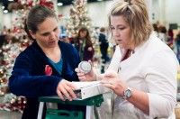 Chandelle Hunt and Kristi Nuckles discuss a signed baseball to be tagged.