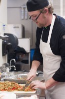 Culinary student is chopping food in the prep area of the Utah State Capitol cafeteria.