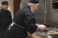 Culinary student Justin Lane is preparing hashbrowns at the grill in the Utah State Capitol cafeteria.