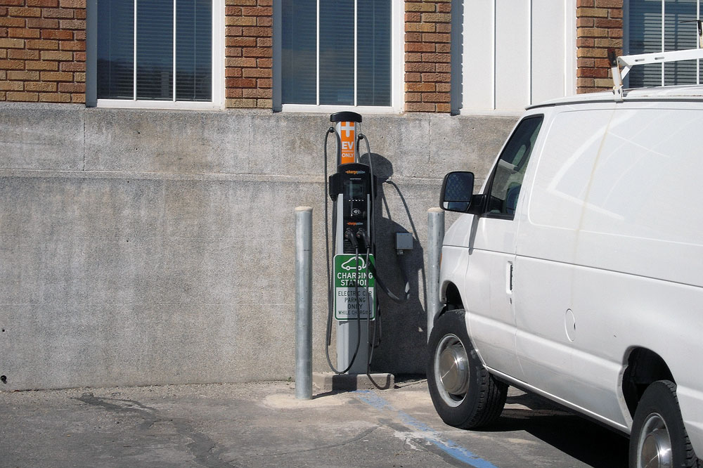 Electric car chargers improve sustainability Van parked in front of charging station