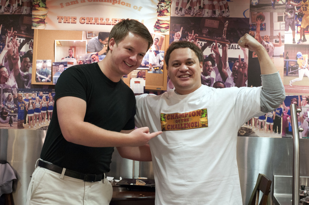 Men eat ridiculous amounts of food to combat obesity Jacob points to David who is wearing the Champion of the Challenge tee shirt.