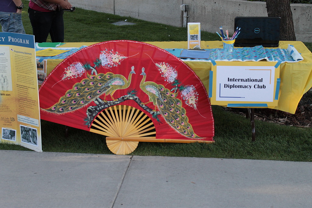 Club Rush brings clubs to the students The International Diplomacy Club's table, decorated with presentation board, a map-themed table decoration, and a very large decorative fan.