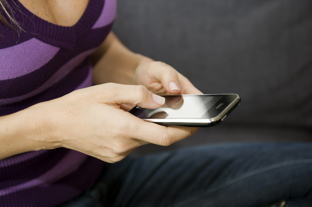 With more functionality, smartphones have become a larger classroom distraction Girl holding smart phone