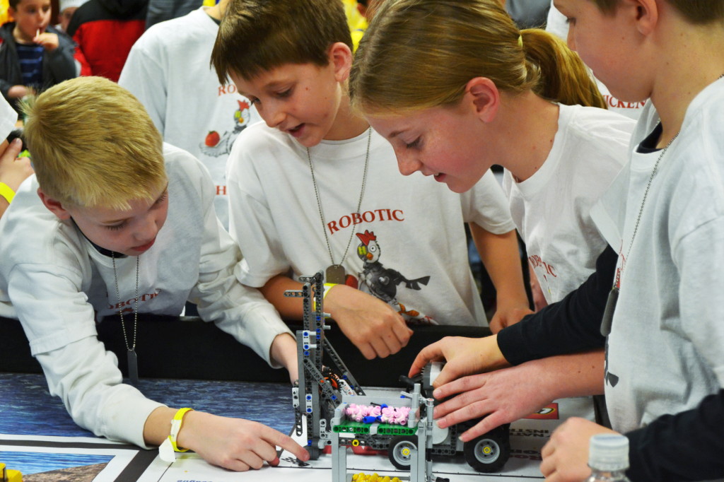 Utah FIRST LEGO League Championship builds character Children gather around a Lego Robot to modify it in the practice room